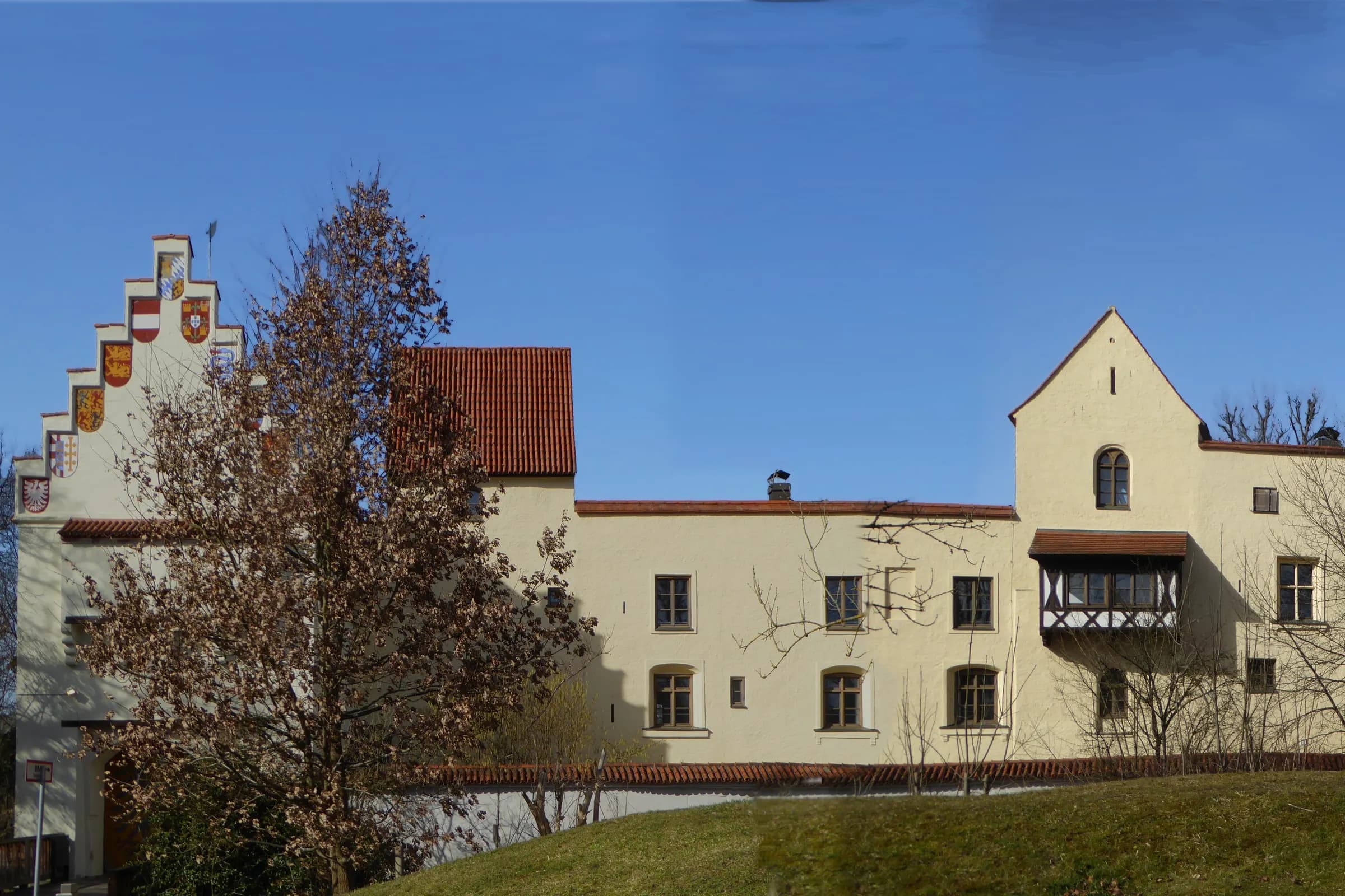 Burg Grünwald mit Wappengiebel über der Wiese