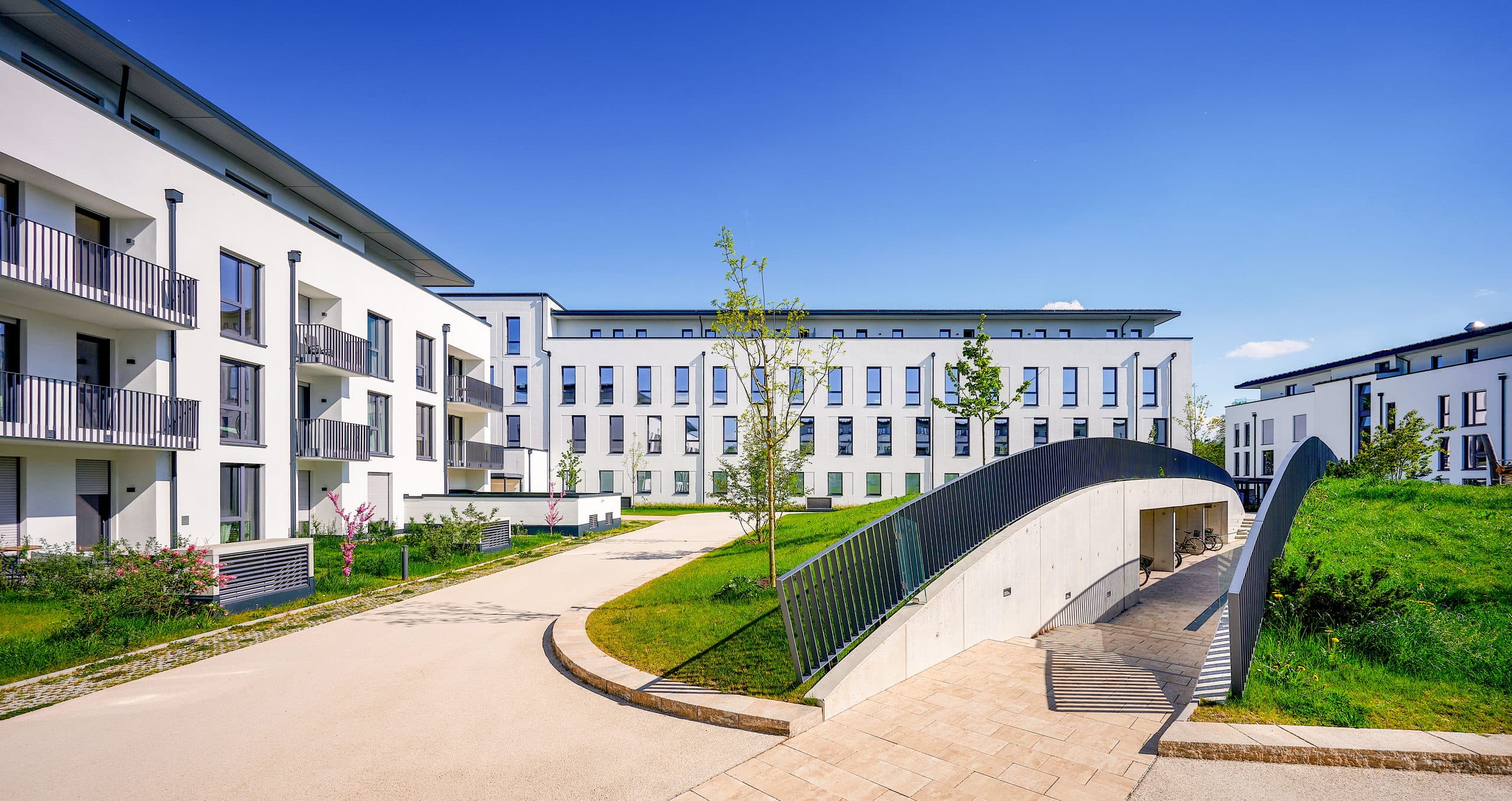 Begrünter Innenhof des Annelies Quartiers mit abgesenktem Durchgang zur Tiefgarage und den Fahrradabstellplätzen