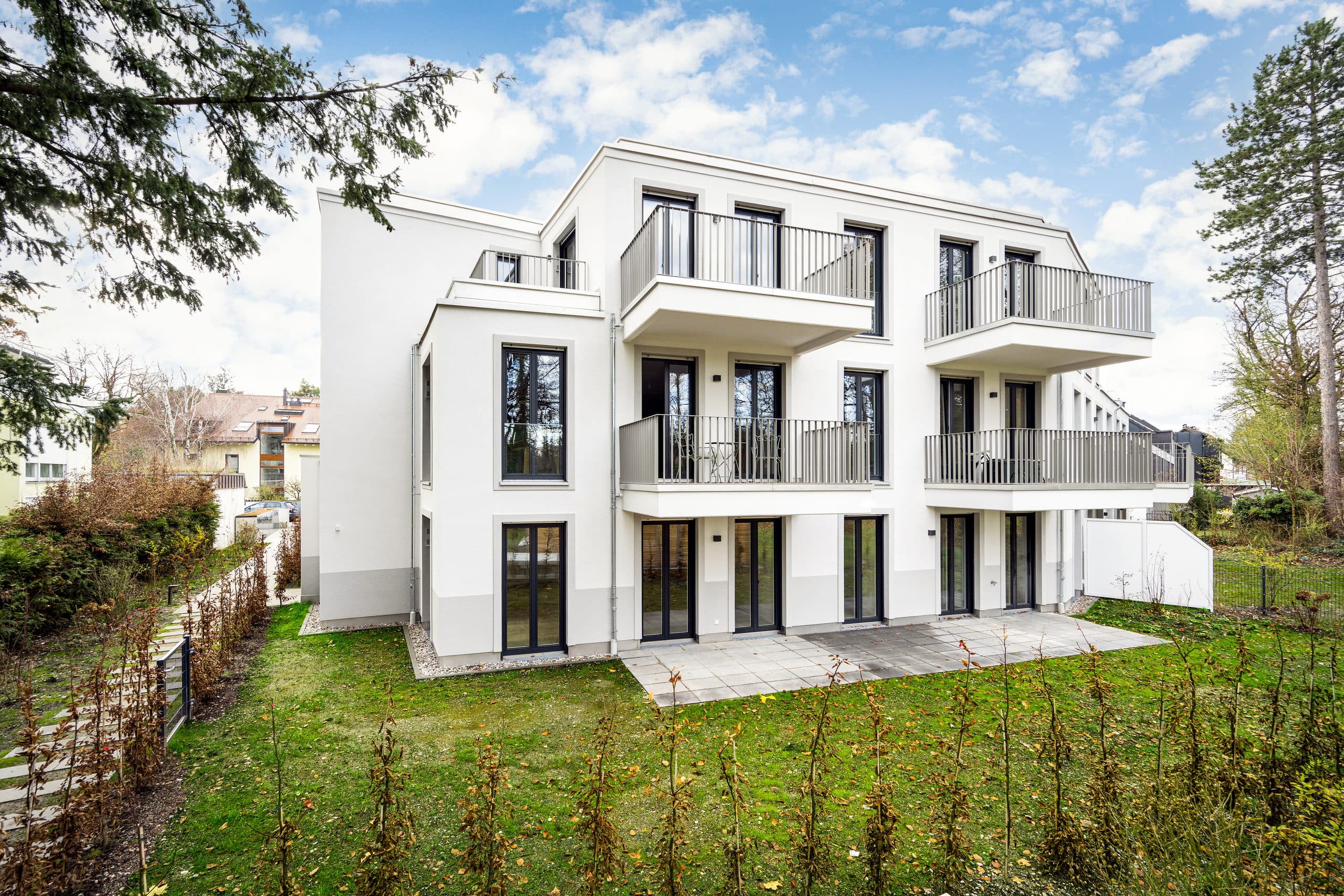 Villa Verde von der Gartenseite: weißer Baukörper mit Balkonen und Terrassen, davor die private Parkanlage