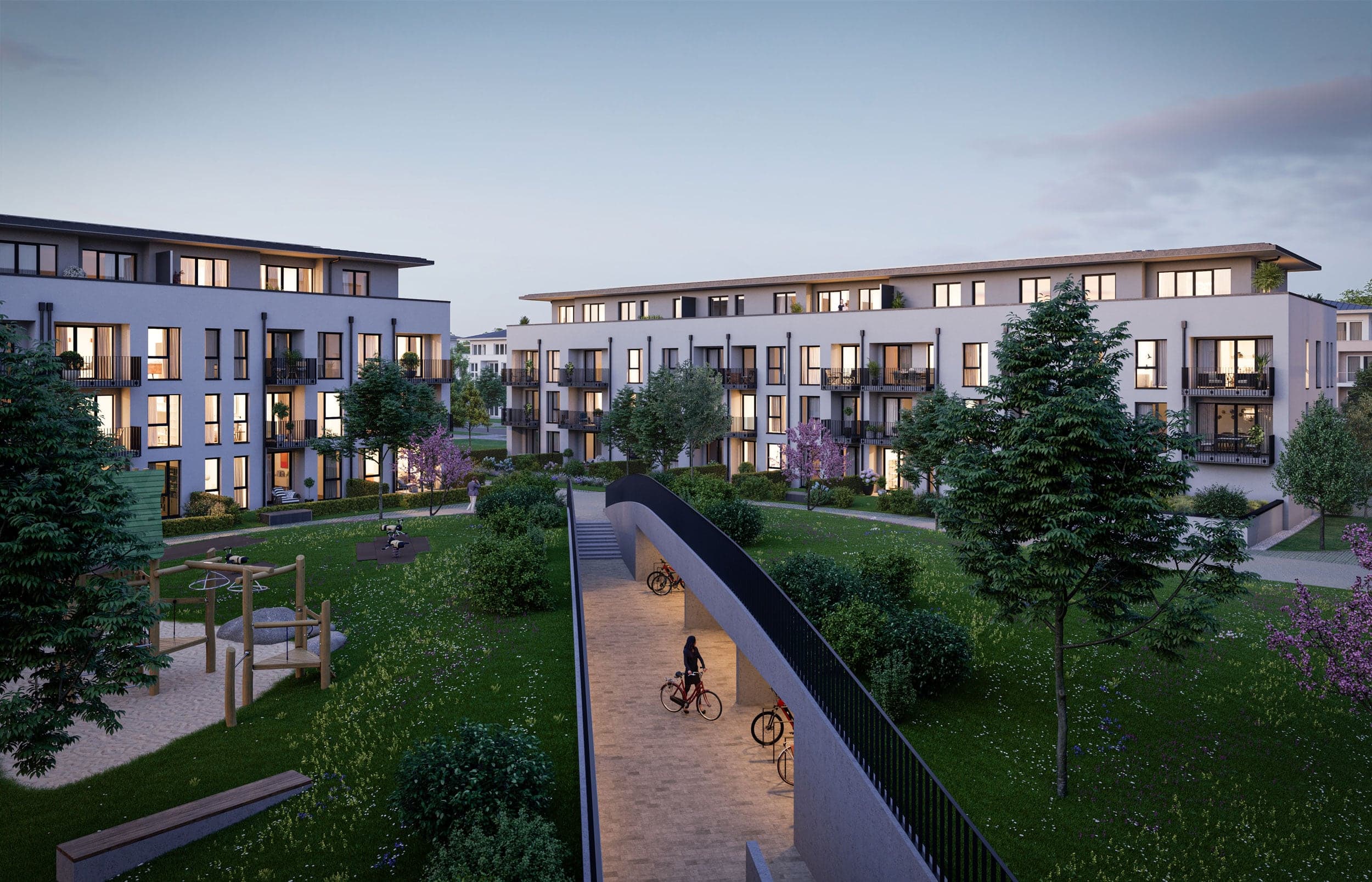 Annelies Quartier Haar bei München — begrünter Innenhof mit Spielplatz und Rampe zur Tiefgarage in der Abenddämmerung