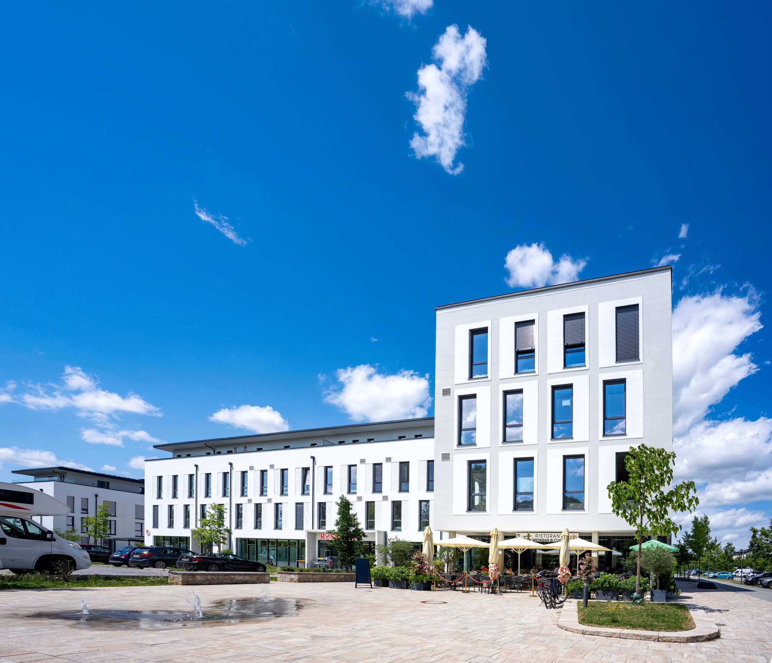 Haus C im Annelies Quartier mit den Gewerbeflächen, davor der Quartiersplatz mit Wasserspiel