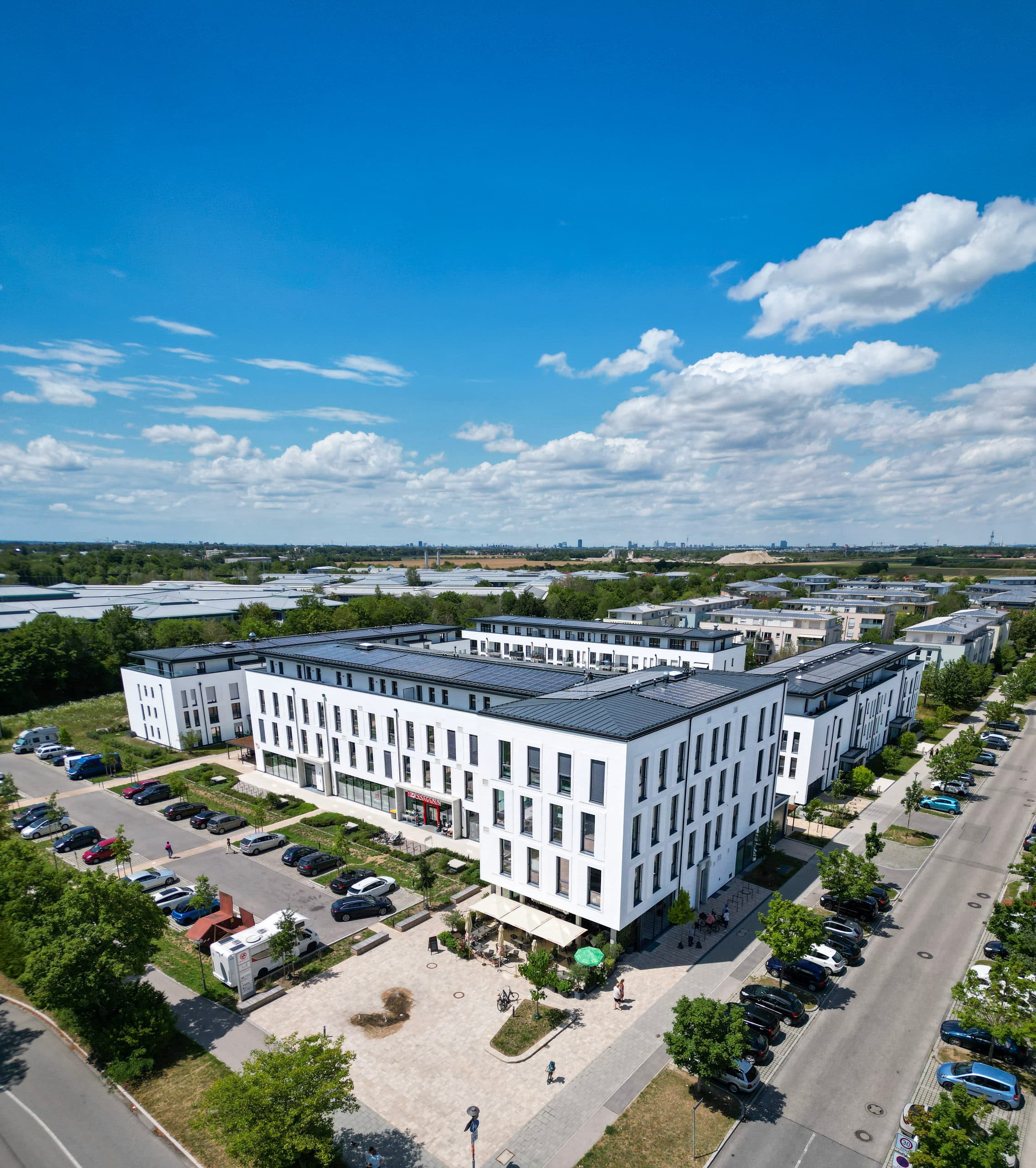 Luftbild von Haus C im Annelies Quartier in Haar mit dem Quartiersplatz und den Wohnhäusern dahinter