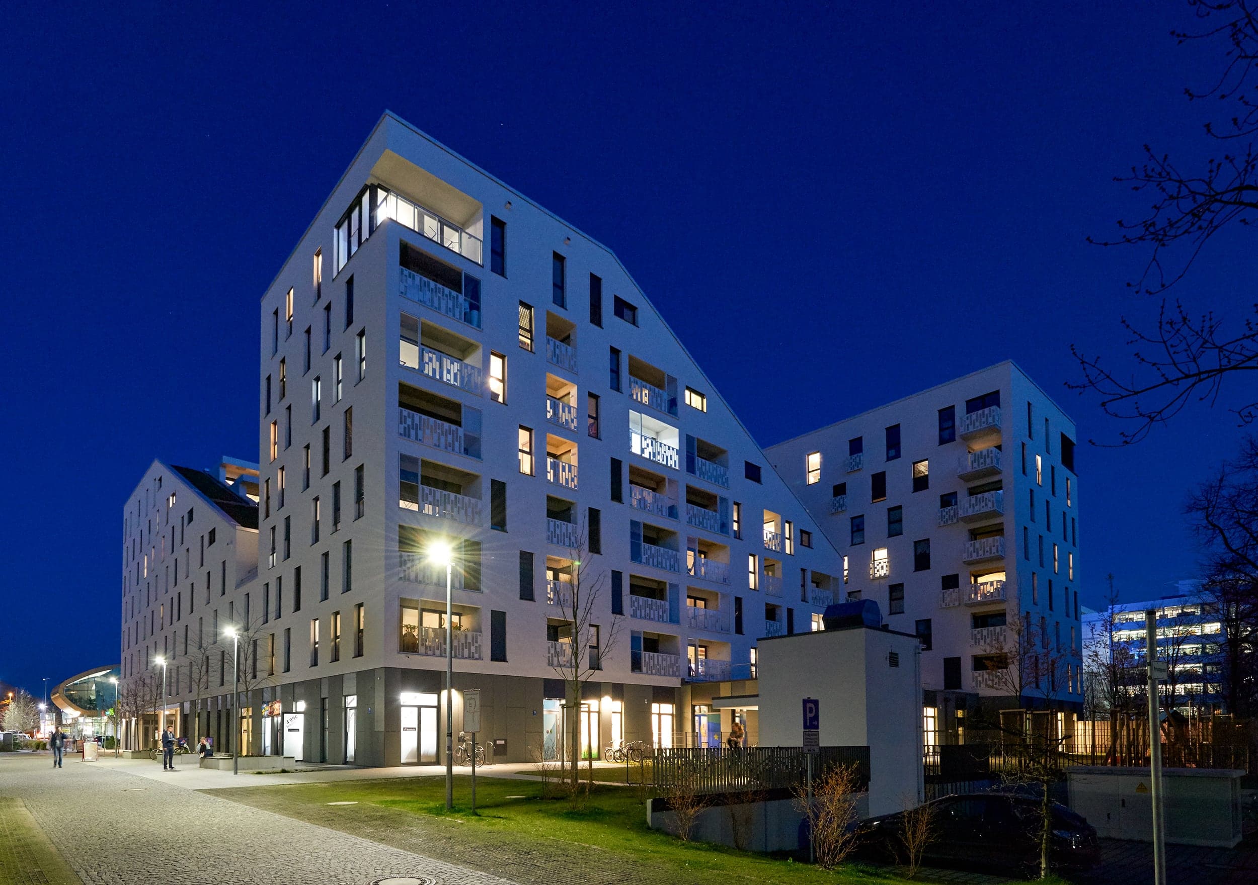 Großes Wohngebäude mit beleuchteten Fenstern bei Nacht